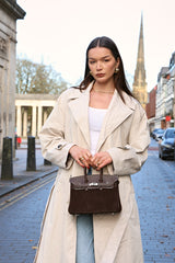 woman holding brown suede medium sized handbag